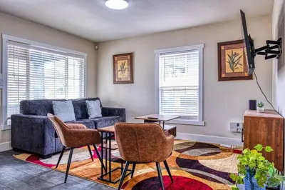 a living room with a couch and a table and chairs at 4BR Victorian Walk to UC Davis & Shriner Med Cen in Sacramento