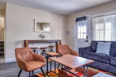 a living room with a couch and a table and chairs at 4BR Victorian Walk to UC Davis & Shriner Med Cen in Sacramento