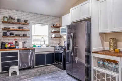 a kitchen with a refrigerator and a sink at 4BR Victorian Walk to UC Davis & Shriner Med Cen in Sacramento