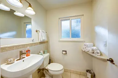 a bathroom with a sink and a toilet and a mirror at Dog-Friendly Oakhurst Home Walk to Downtown! in Oakhurst