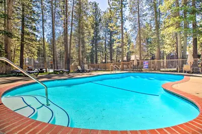 a swimming pool in a yard with trees in the background at Mammoth Lakes Condo with Pool and Spa Access! in Mammoth Lakes