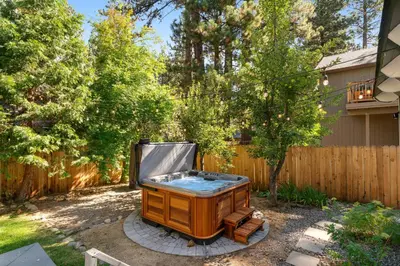 a hot tub in a yard next to a fence at The Home at the End of the Rainbow in South Lake Tahoe