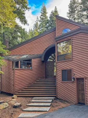 a red house with stairs leading to a door at North Star Mountain Retreat in Truckee