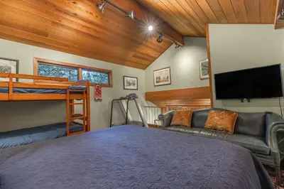 a bedroom with a bunk bed and a couch at Townhouse Art Gallery in Mammoth's Best Location in Mammoth Lakes