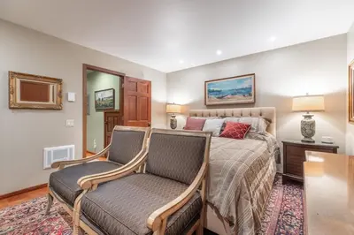 a bedroom with a bed and two chairs at Townhouse Art Gallery in Mammoth's Best Location in Mammoth Lakes