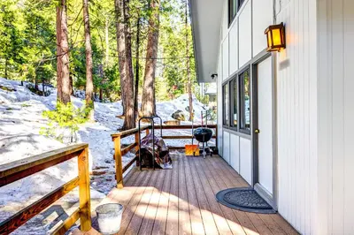 a porch of a house with trees and snow at Hike, Fish and Explore California Cabin with Deck! in Long Barn
