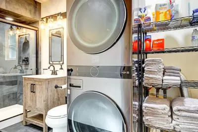 a bathroom with a washing machine and a sink at Hike, Fish and Explore California Cabin with Deck! in Long Barn
