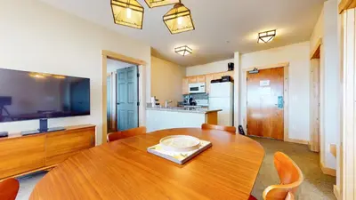 a dining room with a wooden table and a kitchen at Sunstone #231 condo in Mammoth Lakes
