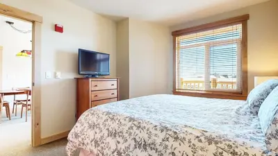 a bedroom with a bed and a flat screen tv at Sunstone #231 condo in Mammoth Lakes