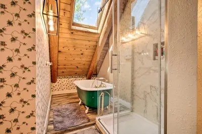 a bathroom with a green tub and a shower at Stunning Log Cabin with Great Views, Firepit, Deck near Twain Hart in Sonora