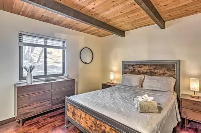 a bedroom with a large bed and a window at Peaceful Oak Haven Cabin near Yosemite in Mariposa