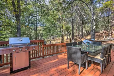 a grill on a deck with a table and chairs at Peaceful Oak Haven Cabin near Yosemite in Mariposa