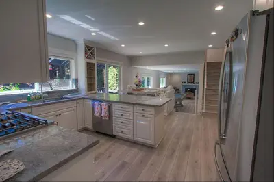 a large kitchen with stainless steel appliances and wooden floors at Creek Side Summit home in Stateline