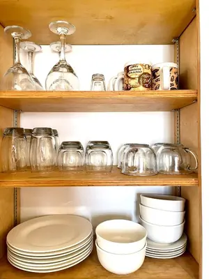 a cabinet filled with plates and bowls and glasses at Sierra Sunset Cottage -Yosemite area vacation cottage in Ahwahnee