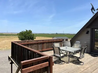 a patio with a table and chairs on a deck at Adorable 1 Bedroom with pool, and Horse Arena in Oakdale