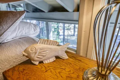 a wooden fish statue on a table next to a vase at Three-Bedroom House in South Lake Tahoe
