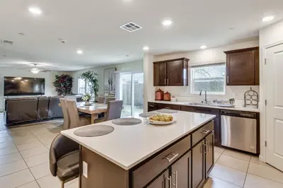 a kitchen with an island in the middle of a room at Pool Table and Patio! Spacious Merced Getaway in Merced