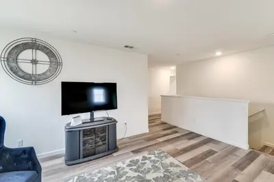 a living room with a flat screen tv on a wall at Pool Table and Patio! Spacious Merced Getaway in Merced