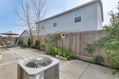a backyard with a wooden fence and a heater at Pool Table and Patio! Spacious Merced Getaway in Merced