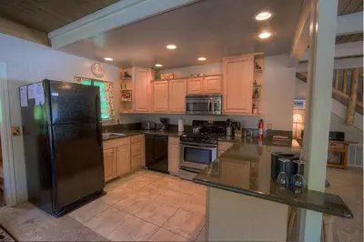 a kitchen with wooden cabinets and a black refrigerator at Rocky Top Retreat home in South Lake Tahoe