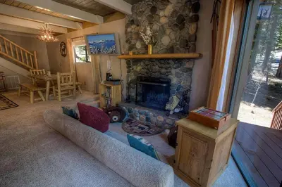 a living room with a stone fireplace and a couch at Rocky Top Retreat home in South Lake Tahoe