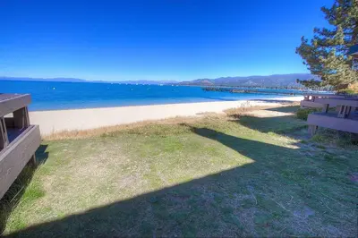 a view of a beach with a bench and the ocean at Sky Lake Splendor condo in South Lake Tahoe