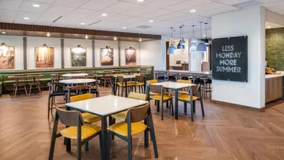 a restaurant with tables and chairs and a chalkboard at Fairfield by Marriott Inn & Suites Stockton Lathrop in Lathrop