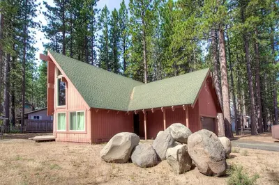 a small red house with rocks in front of it at Snowshoe Chalet cabin in South Lake Tahoe