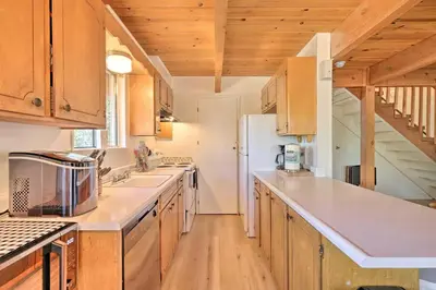 a kitchen with wooden cabinets and a white refrigerator at Pine Mountain Lake Cabin with Grill! in Groveland