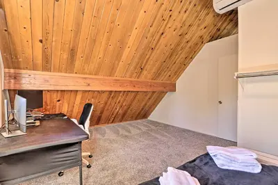 an attic room with a desk and a refrigerator at Pine Mountain Lake Cabin with Grill! in Groveland
