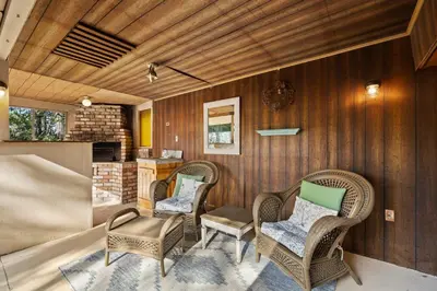 a living room with wicker chairs and a kitchen at Twain Harte Cabin in Town & Lake access in Twain Harte