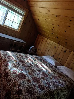 a bedroom with a bed in a wooden room at Cabin #3 in Strawberry