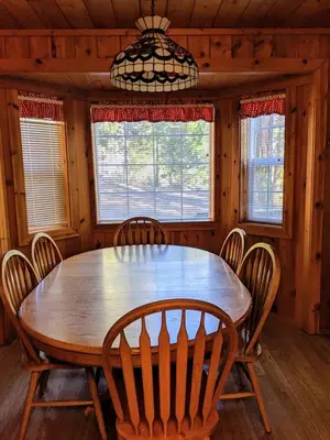 a wooden dining room table with chairs and a chandelier at Cabin #3 in Strawberry
