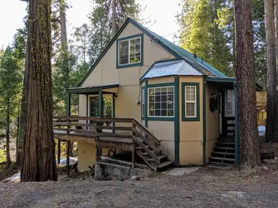 a small house with a porch in the woods at Cabin #3 in Strawberry