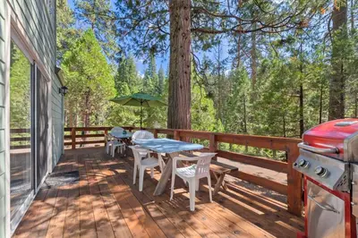 a deck with a table and chairs and a grill at Cabin #4 in Strawberry