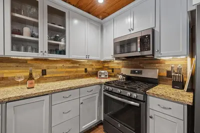 a kitchen with white cabinets and a stove and microwave at Cabin #4 in Strawberry