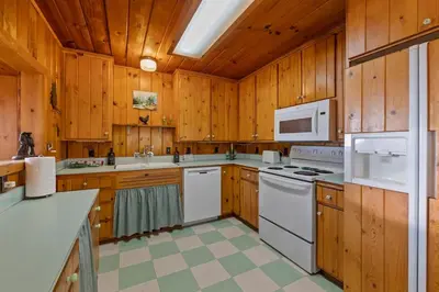 a kitchen with white appliances and wooden cabinets at Cabin #5 in Strawberry
