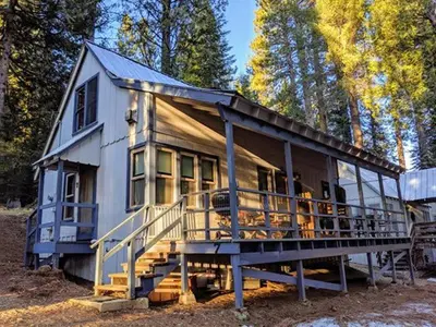 a large house with a large deck in the woods at Cabin #7 in Strawberry