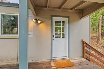 a house with a white door and a porch at Cabin #6 in Strawberry