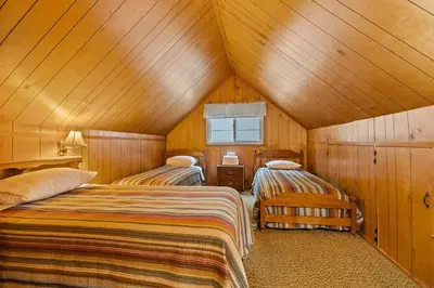 two beds in a room with wooden walls at Cabin #10 in Strawberry