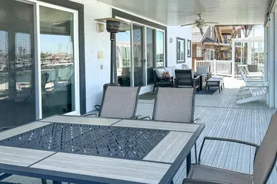 a patio with chairs and a table on a porch at Private Dock Discovery Bay Vacation Rental! in Discovery Bay