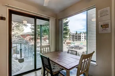 a dining room with a wooden table and a balcony at Heavenly Mountain Lake Retreat Near Skiing, Hiking & Biking in Stateline