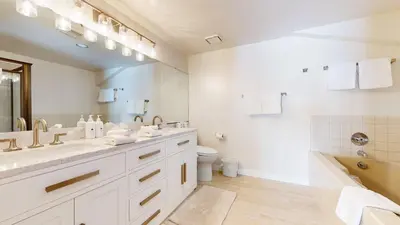 a bathroom with two sinks and a toilet and a tub at Bridges #308 condo in Mammoth Lakes