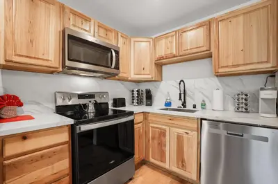 a kitchen with wooden cabinets and a black stove top oven at Heavenly Lakeside Retreat Close to downtown in South Lake Tahoe