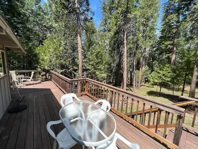 a wooden deck with a table and chairs on it at Blue Lake Chalet- 3 Bedroom + Loft/Pool Table in Arnold/Bear Valley (Pet-Friendly) in Arnold