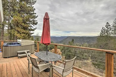 a patio with a table and chairs on a deck at Homey Colfax Getaway with Private Hot Tub! in Colfax