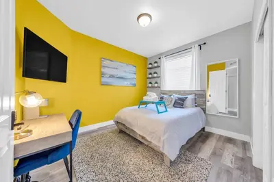 a bedroom with a yellow wall with a bed and a desk at Luxe & Comfy Vineyard Estate ~ Breathtaking Views! in Clarksburg