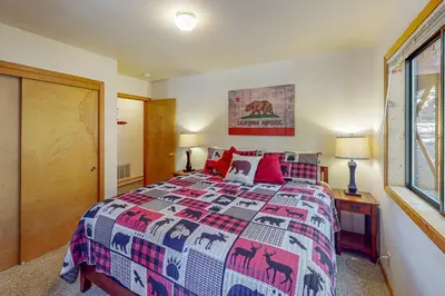 a bedroom with a bed with a quilt with animals on it at Hansel Hideaway in Truckee