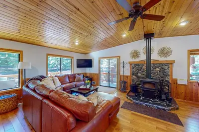 a living room with a leather couch and a fireplace at Hansel Hideaway in Truckee