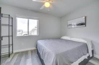 a white bedroom with a bed and a window at Renovated Hawthorne Apartment By Museums and Dining! in Hawthorne